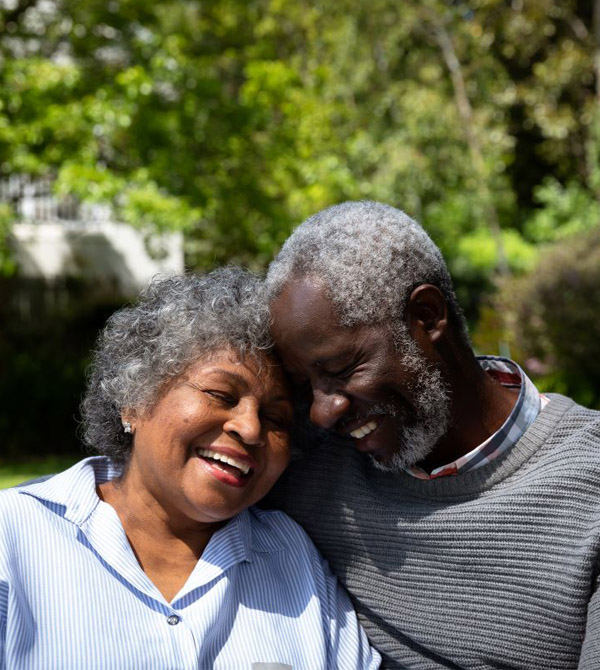 elderly couple smiling on a bench